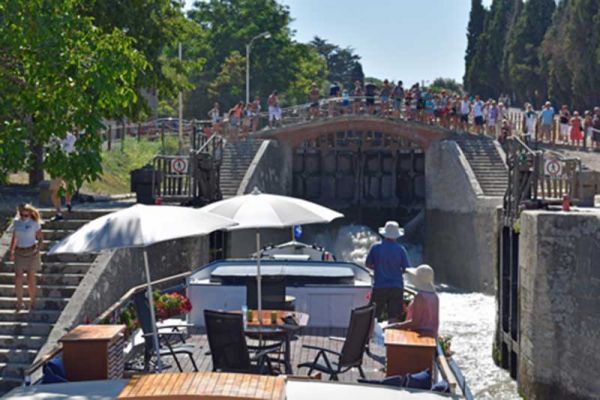 Luxury barge cruise Anjodi approaching a lock with onlookers