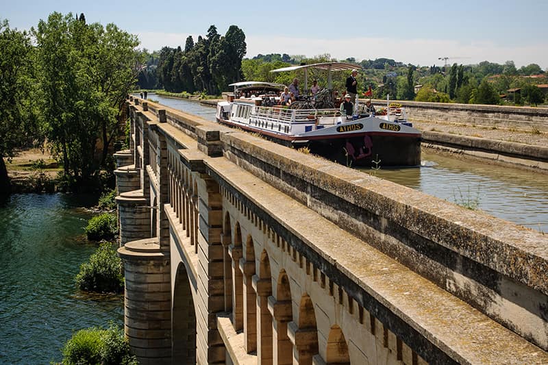 Hotel barge Athos crossing an aqueduct in the Canal du Midi