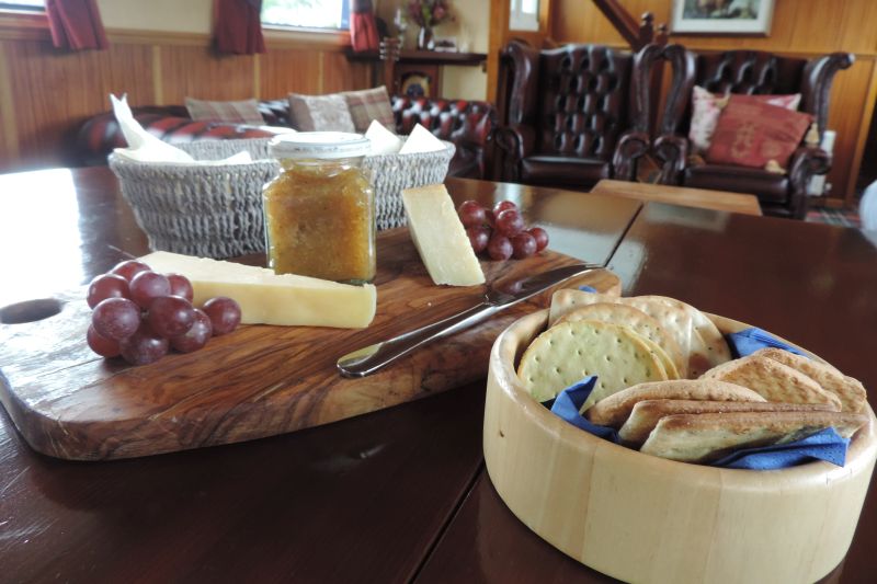 Cheese and accompaniments with crackers on wooden board