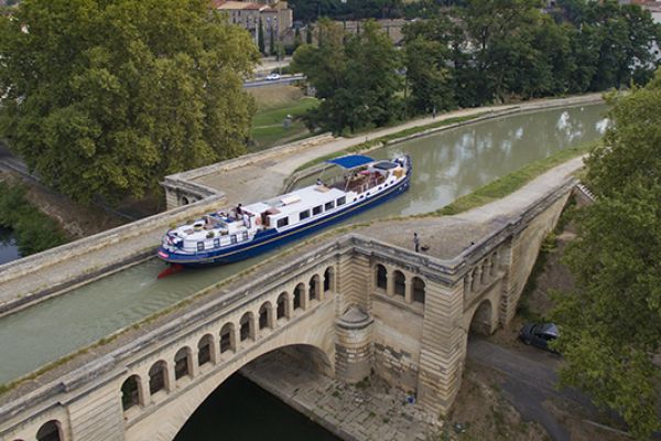 Luxury Hotel Barge Anjodi, cruising in Southern France on a viduct on the Canal du Midi