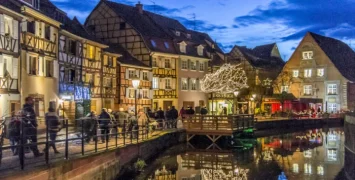 Christmas market cruises showcase traditional holiday season feelings with lit medieval houses, decorated trees and snow falling on the canals.
