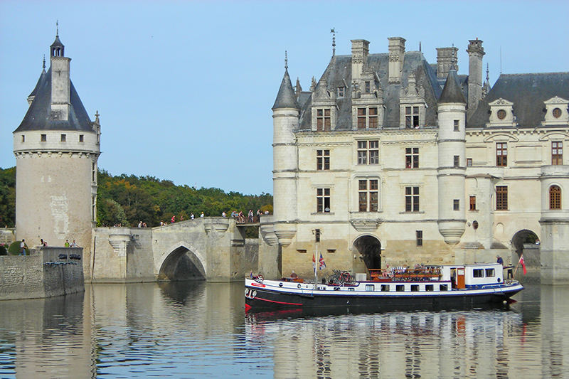 Hotel barge Nymphea cruising in front of the chateau de chenonceau