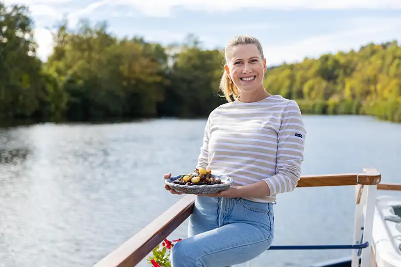 Justine Schofield holding her plate of Beef Bourgignon aboard hotel barge La Belle Epoque