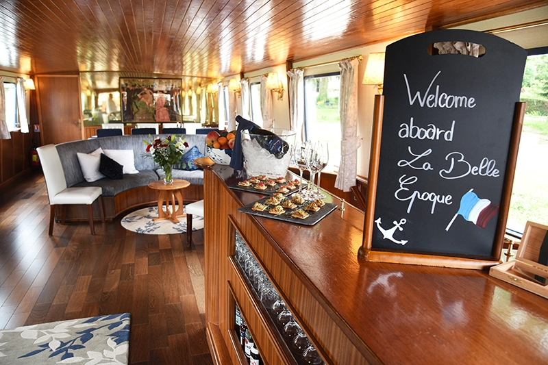 Semi circular sofas in the saloon aboard hotel barge La Belle Epoque