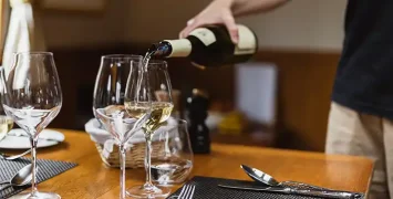 Host pouring wines at the dinner table