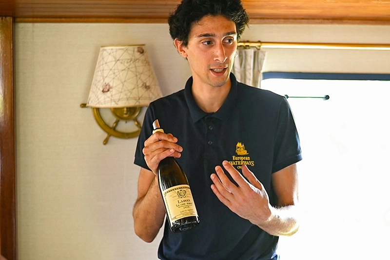Host presenting wines aboard hotel barge La Belle Epoque in Burgundy