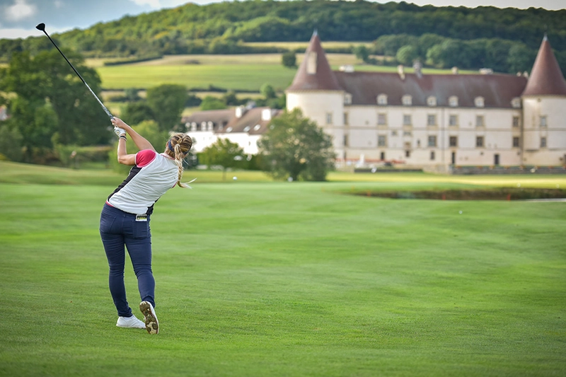 Lady hitting the ball towards the green