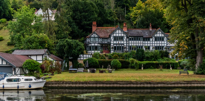 40th anniversary cruise on Magna Carta on the River Thames England. Cruising past Judith Potts medieval style manor house.