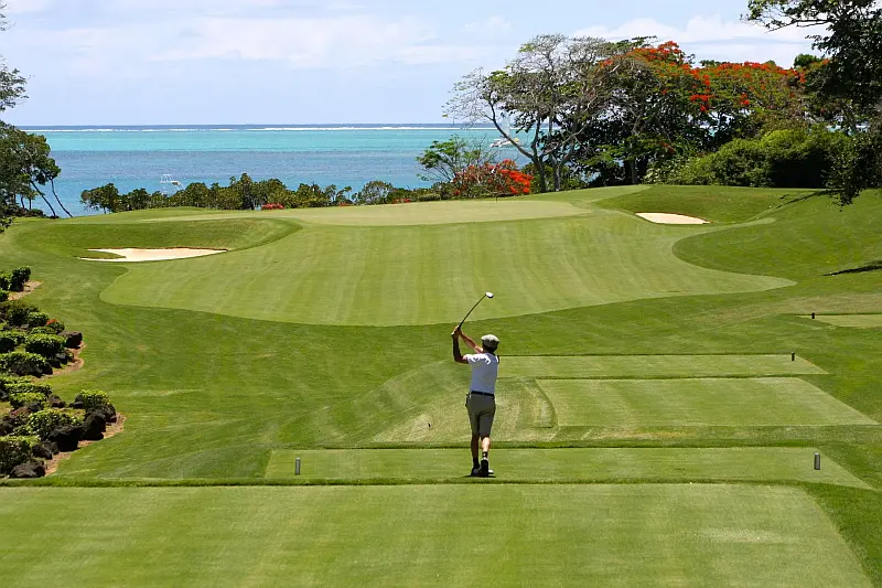 Person playing golf with ocean in the distance